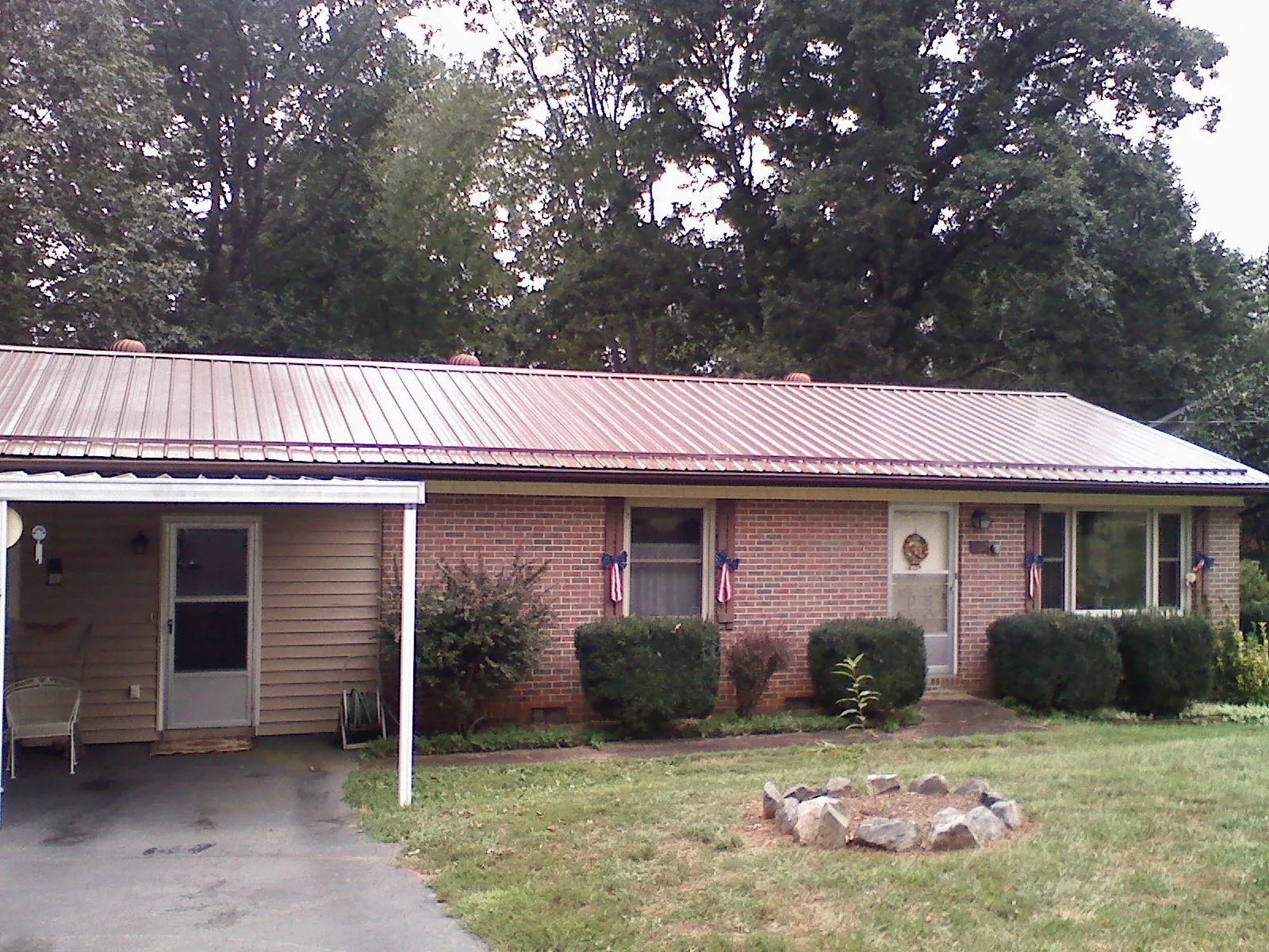 Bronze metal roof and carport on a brick ranch home — Roof Repair work by our crew in Grayland